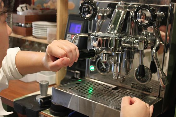 Placing a tamped portafilter into the espresso machine